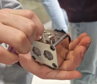 Figure 9: A girl is screwing the check valve with the check valve holder into the pump head. Everything is then tightened using a torque wrench.