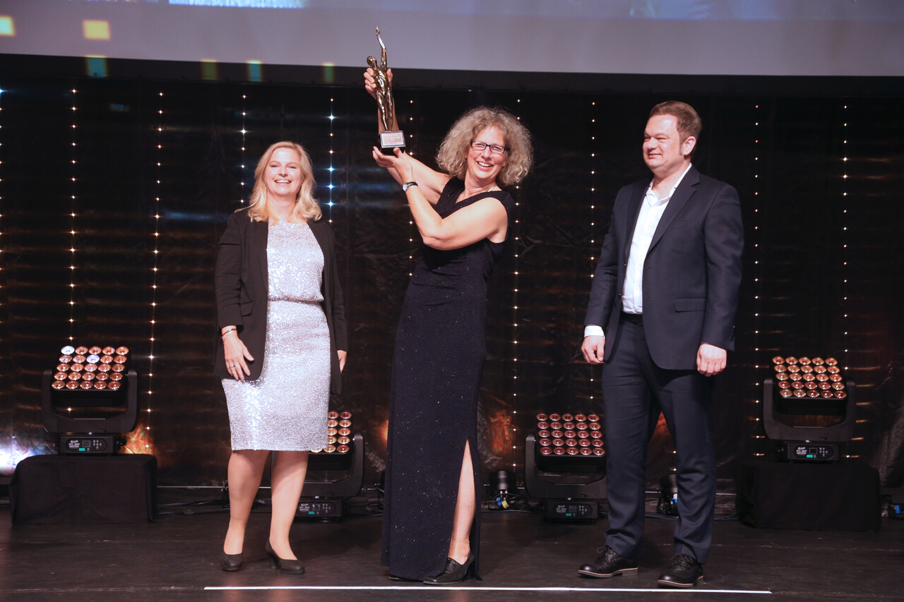 Katharina Pohl, Alexandra Knauer und Carsten Losch mit der Award-Statue 