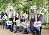 Gruppenfoto von KNAUER-Mitarbeitern, die Plakate mit nachhaltigen Zielen hochhalten