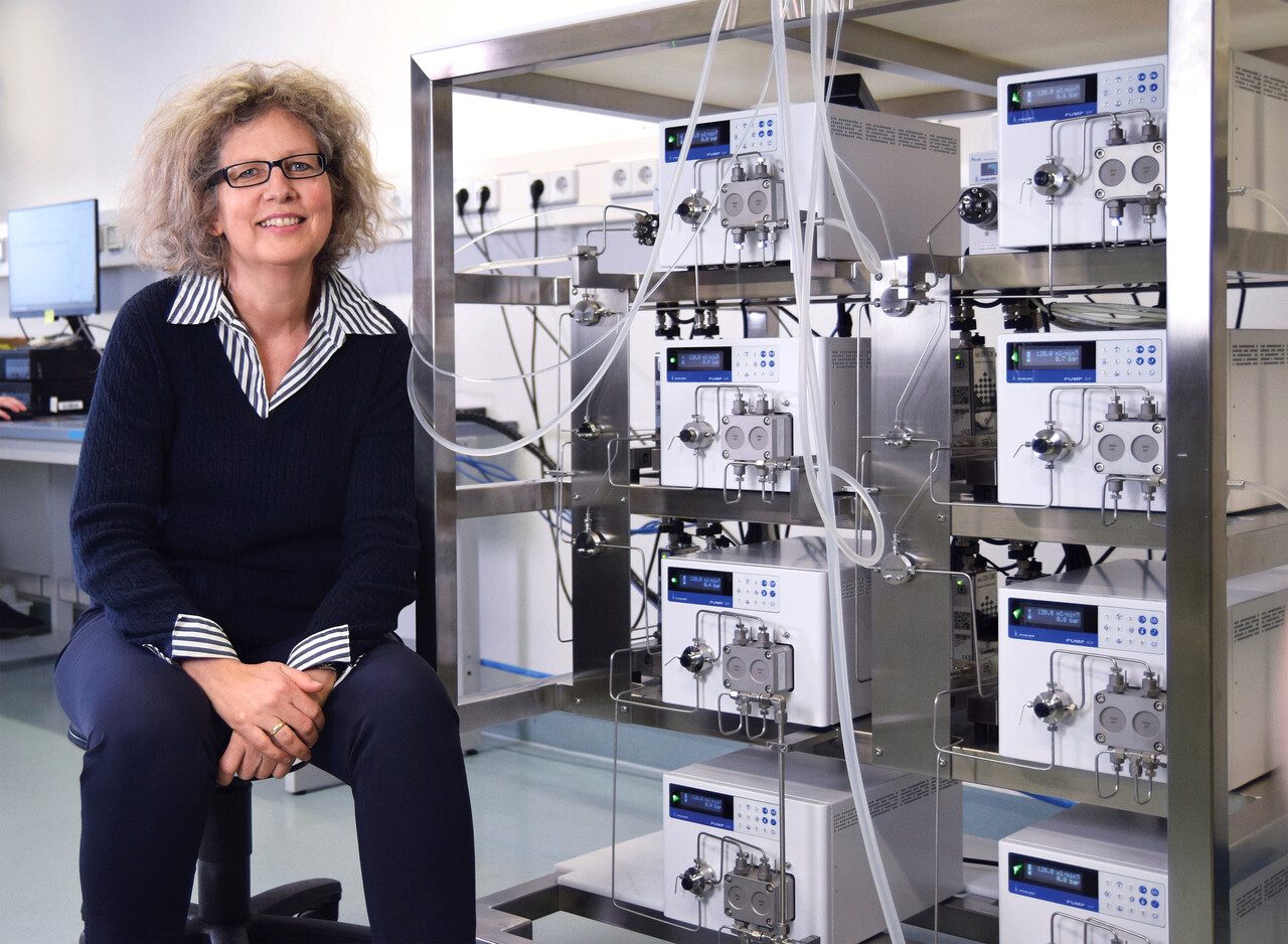 Alexandra Knauer neben einer IJM-Anlage zur Herstellung von Lipid-Nanopartikeln